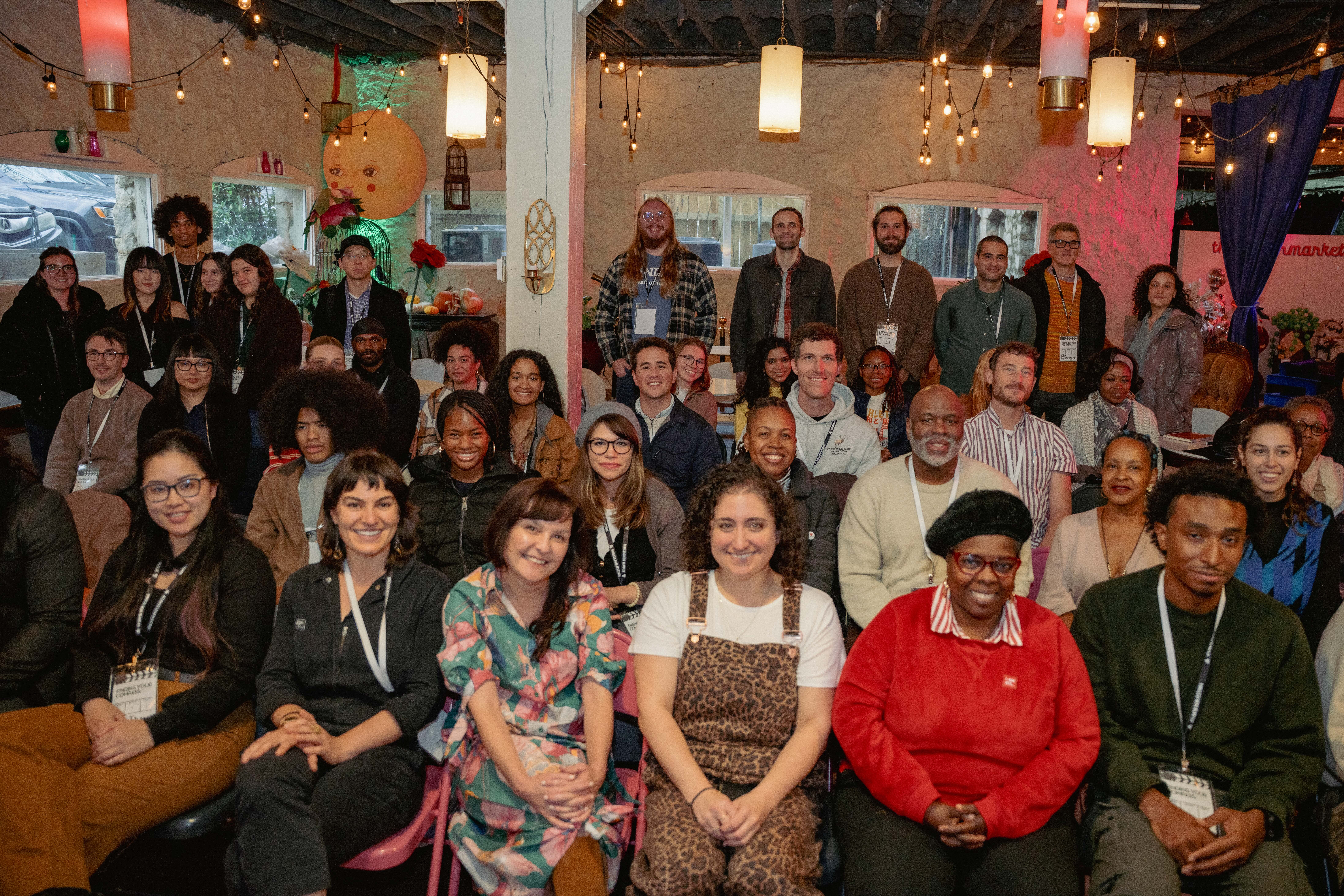 Diverse group of people sitting in rows with big smiles.
