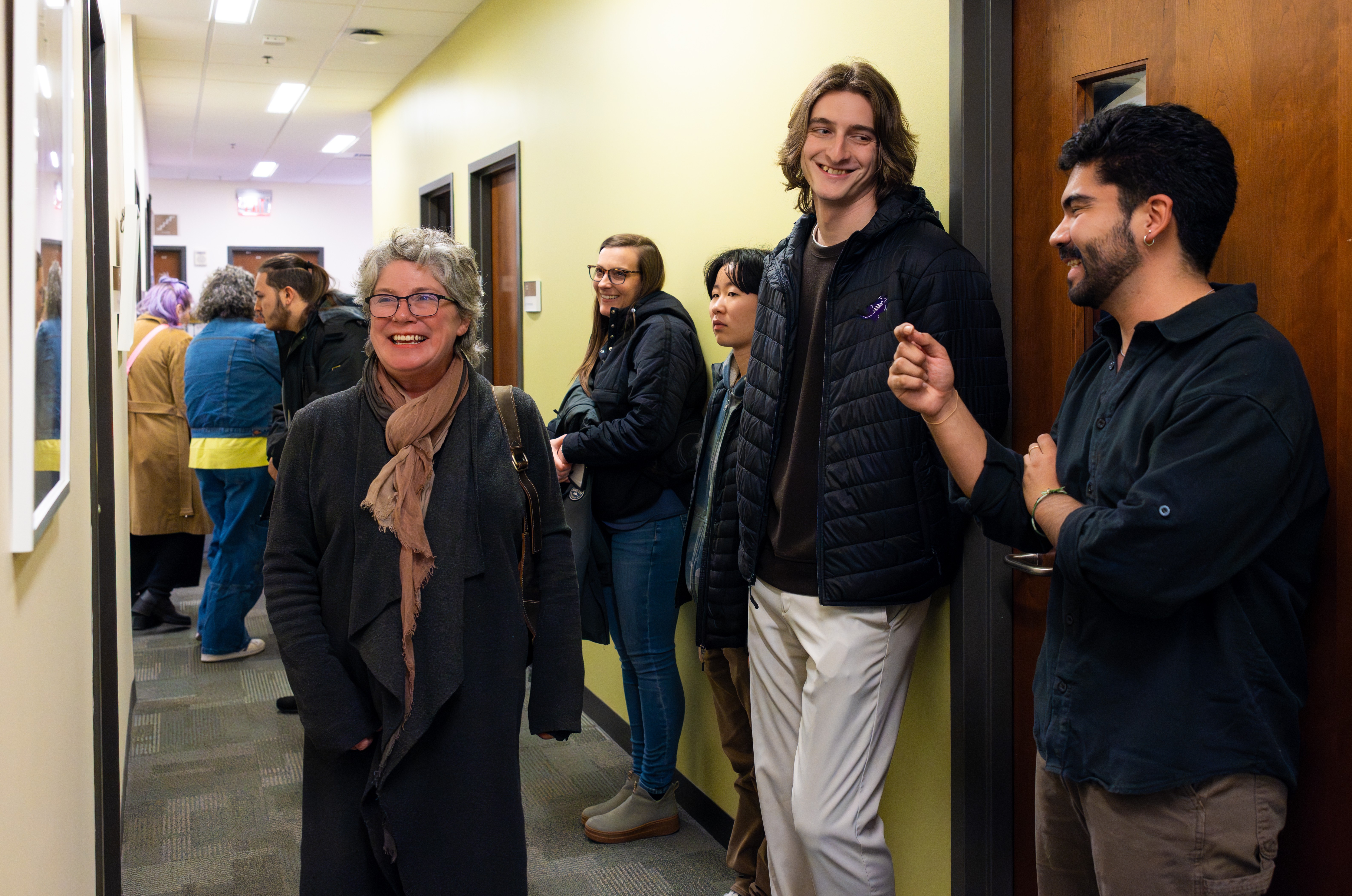 Group of people viewing art exhibit and smiling